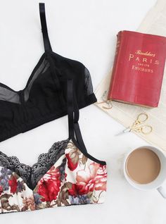 an open bra next to a book and cup of coffee on a white table top