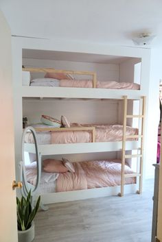 there are bunk beds in the room with pink sheets and pillows on top of them