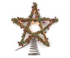 a christmas star decoration hanging from a wire on a white background with red berries and greenery