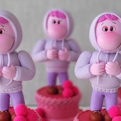 three figurines are standing in front of a cake with frosting on it