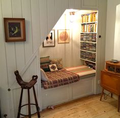 there is a small window seat in the room with bookshelves on the wall