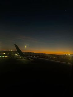 an airplane is sitting on the runway at night