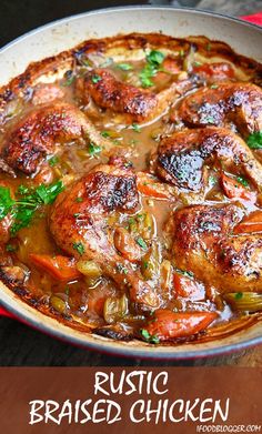 a pan filled with meat and vegetables on top of a wooden table