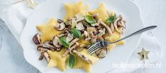 a white plate topped with pasta and mushrooms