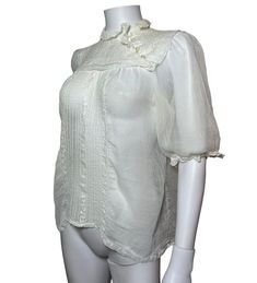 An elegant and versatile late Edwardian blouse made from a semi sheer cotton (like lawn but not quite as smooth).  There are short sleeves with lace trim. These are elasticated but the elastic has lost nearly all of its ping, if you want them tight this could be replaced.  The neck is high with mother of pearl buttons on the diagonal down the yoke so that it slips over the head.  Three deep tucks give the effect of a sailor collar and the front yoke has embroidery and drawn work.  Since I took t Fitted Cotton Lace Top With Short Sleeves, Fitted Summer Blouse With Crochet Trim, Fitted Blouse With Crochet Trim For Summer, Summer Stretch Top With Lace Collar, Lace Collar Top For Summer Daywear, Summer Lace Collar Top For Daywear, Summer Lace Top With Lace Collar, Summer Lace Top With Lace Collar For Daywear, Summer Cotton Lace Top With Short Sleeves