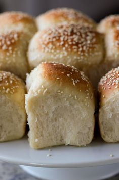 several rolls on a plate with sesame seeds sprinkled on them and sitting in the middle