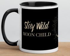 a black and white coffee mug with the words, stay wild moon child on it