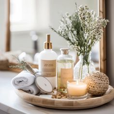 a tray with candles, soaps and other items on it next to a mirror