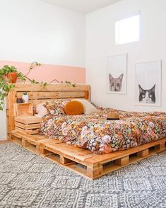 a bed made out of wooden pallets in a room with pink walls and rugs