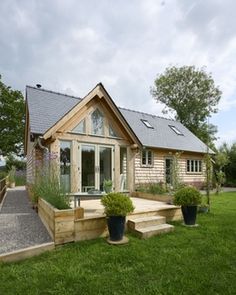 a small wooden house sitting on top of a lush green field next to a stone walkway