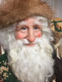 a close up of a santa clause wearing a fur hat and green sweater with gold trim