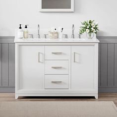 a white bathroom vanity with two sinks and a mirror