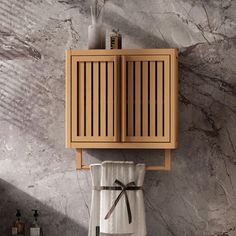 a wooden cabinet on the wall above a towel rack