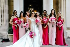 a group of women standing next to each other in front of a building holding bouquets