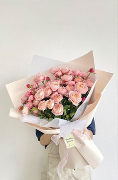 a person holding a bouquet of pink roses