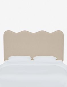 an upholstered headboard on a bed with white sheets and pillows, against a plain background