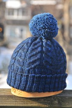 a blue knitted hat sitting on top of a wooden table