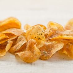 a pile of potato chips sitting on top of a wooden table