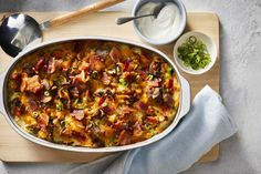 a casserole dish with meat and vegetables on a cutting board next to other dishes