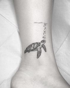 a small turtle tattoo on the ankle with bubbles coming out of its mouth and tail