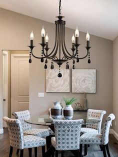 a dining room table with chairs and a chandelier hanging from it's ceiling