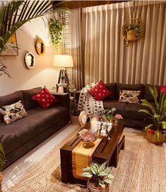 a living room with two couches, coffee table and potted plants in it