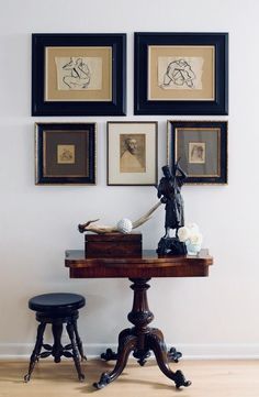 a table with two stools and pictures on the wall