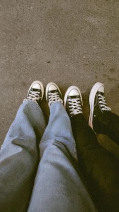 two people standing next to each other wearing tennis shoes