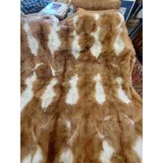 a brown and white spotted animal fur on a couch in a living room with chairs