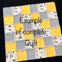 the rag quilt kit is made with yellow, grey and white squares on black fabric