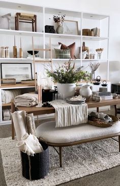 a living room filled with lots of furniture and bookshelves on top of shelves