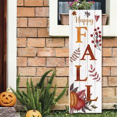 a sign that says happy fall next to some pumpkins