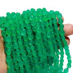 a hand holding a bunch of green beads