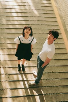 two young people are walking up some stairs