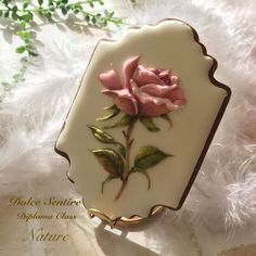 a pink rose sitting on top of a white plate