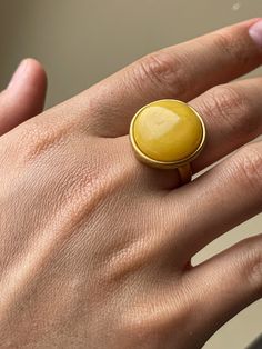 This unique ring is a special piece from Strelnik Jewelry. Made with care, it features high-quality sterling silver with a matte gold finish, giving it a touch of luxury. At the center, you'll find a beautiful piece of natural amber, known for its stunning colors and natural beauty. This ring is more than just jewelry; it's a standout accessory that adds something special to any outfit. Strelnik Jewelry prides itself on creating unique, easy-to-love pieces that make you stand out. The jewelry is Modern Yellow Gold Cabochon Rings, Timeless Gold Dome Ring With Cabochon, Modern Yellow Gold Dome Ring With Cabochon, Elegant Yellow Open Ring, Modern Gold Signet Ring With Cabochon, Modern Yellow Rings For Anniversary, Yellow Tarnish-resistant Jewelry, Elegant Brass Rings With Cabochon, Elegant Yellow Hallmarked Signet Ring