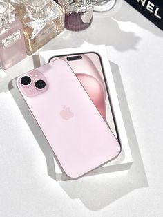 two pink iphones sitting next to each other on top of a white countertop