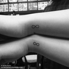 two people with matching tattoos on their arms are holding each other's hands together