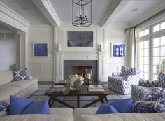 a living room filled with furniture and a fire place in the middle of a room