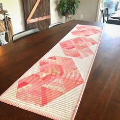 a wooden table with a red and white quilt on it