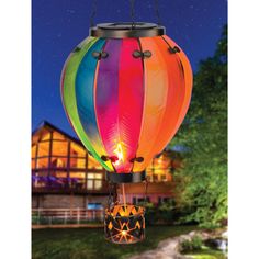 a multicolored lantern hanging from a chain in front of a house at night