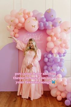 a woman standing in front of balloons with the words, we're your baby shower theme