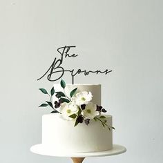 there is a white cake with flowers on the top and the words, the b'gourds