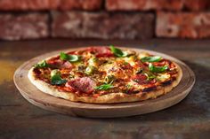 a pizza sitting on top of a wooden cutting board