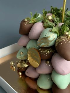 chocolate covered strawberries are arranged on top of each other with gold leafy decorations