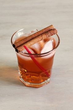 a glass filled with ice and cinnamon sticks