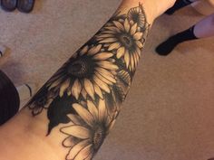 a woman's arm with a sunflower tattoo on it