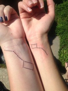 two people with matching wrist tattoos on their arms, one is holding the other's hand