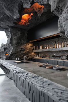 the bar is made out of stone and has an orange light coming from it's ceiling