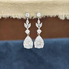 Adorned with a delicate floral leaf design and embellished with mesmerizing marquise-cut zircon stones, these earrings exude a timeless charm. The captivating teardrop silhouette adds a touch of sophistication to any ensemble, making them the perfect accessory for your special day. 💖 These bohemian-inspired earrings are a seamless blend of modern and vintage aesthetics, making them a versatile choice for boho floral wedding themes. Whether you are a bride, bridesmaid, or a mother of the bride, Elegant Linear Drop Earrings For Wedding, Elegant Wedding Drop Linear Earrings, Crystal Dangle Earrings For Wedding, Delicate Bridal Drop Earrings With Elegant Design, Delicate Teardrop Bridal Earrings For Wedding, Delicate Formal Bridal Dangle Earrings, Wedding Bridal Drop Earrings, Dangle Teardrop Earrings For Wedding, Silver Long Drop Wedding Earrings